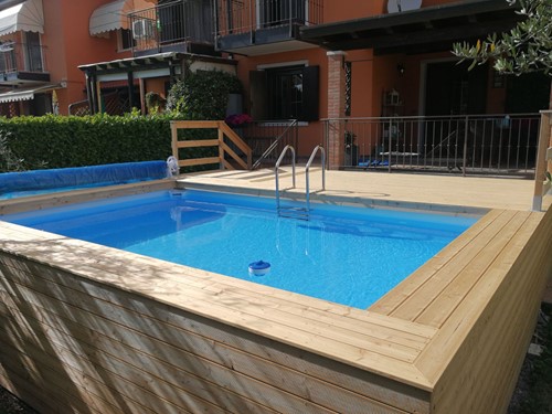 2. Terrazzo e piano piscina . Tutta rivestita in legno di larice siberiano ideale per l'esterno .La piscina è completa di rullo avvolgitore per il telo estivo di copertura .