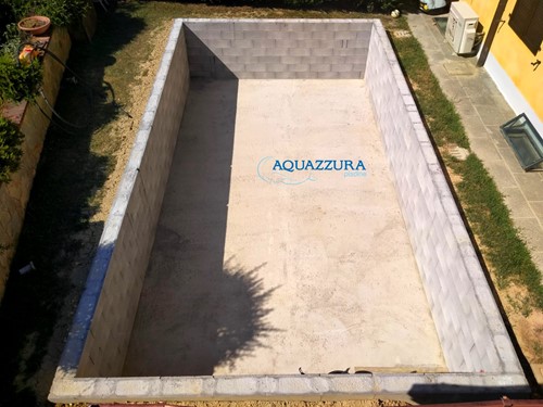 17. Platea in cemento e muretti. Platea e muretto perimetrale che ospita la piscina fuori terra seminterrata.